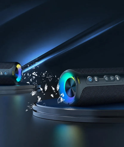 Black portable speaker beside a record player with RGB lighting.